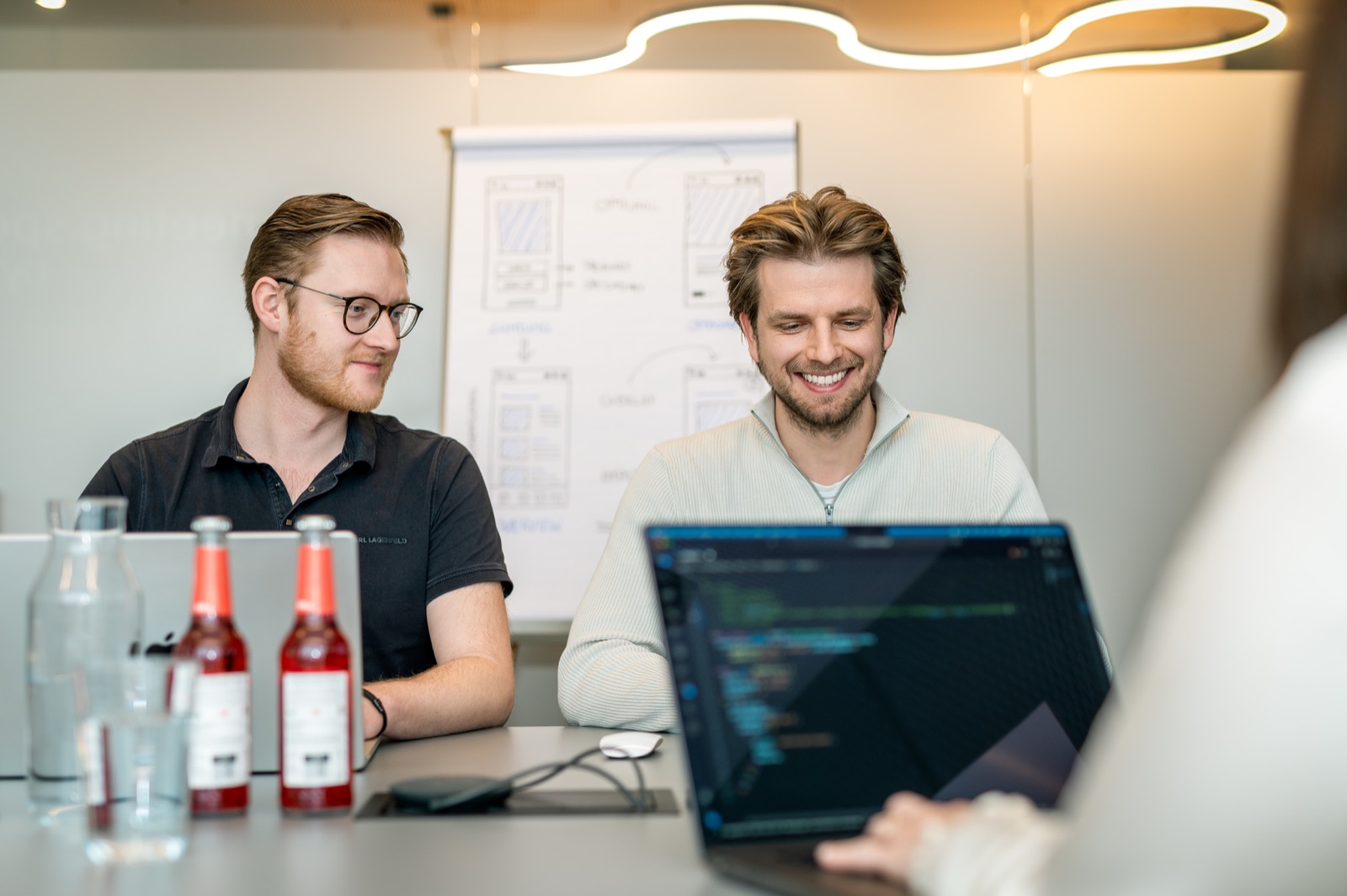 Team members discuss source code together