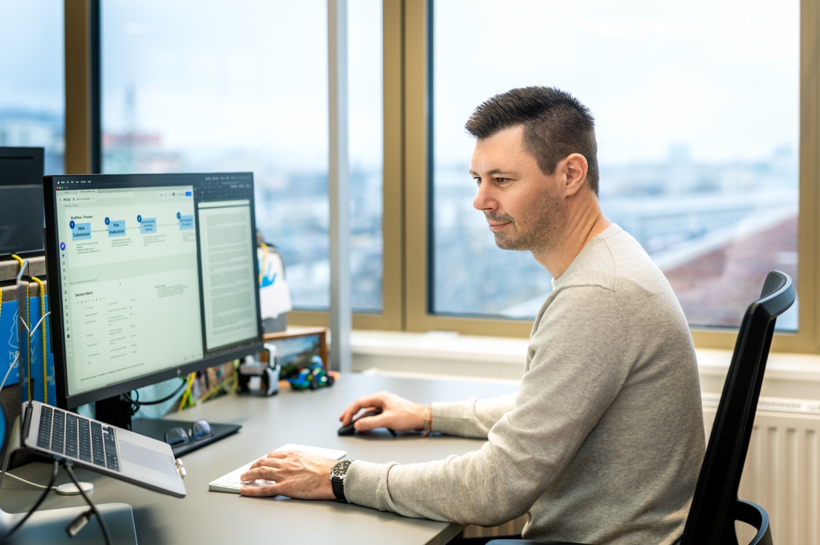 Christof Stromberger works at multiple screens in the Denovo office